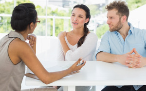 Therapist talking with couple sitting at desk